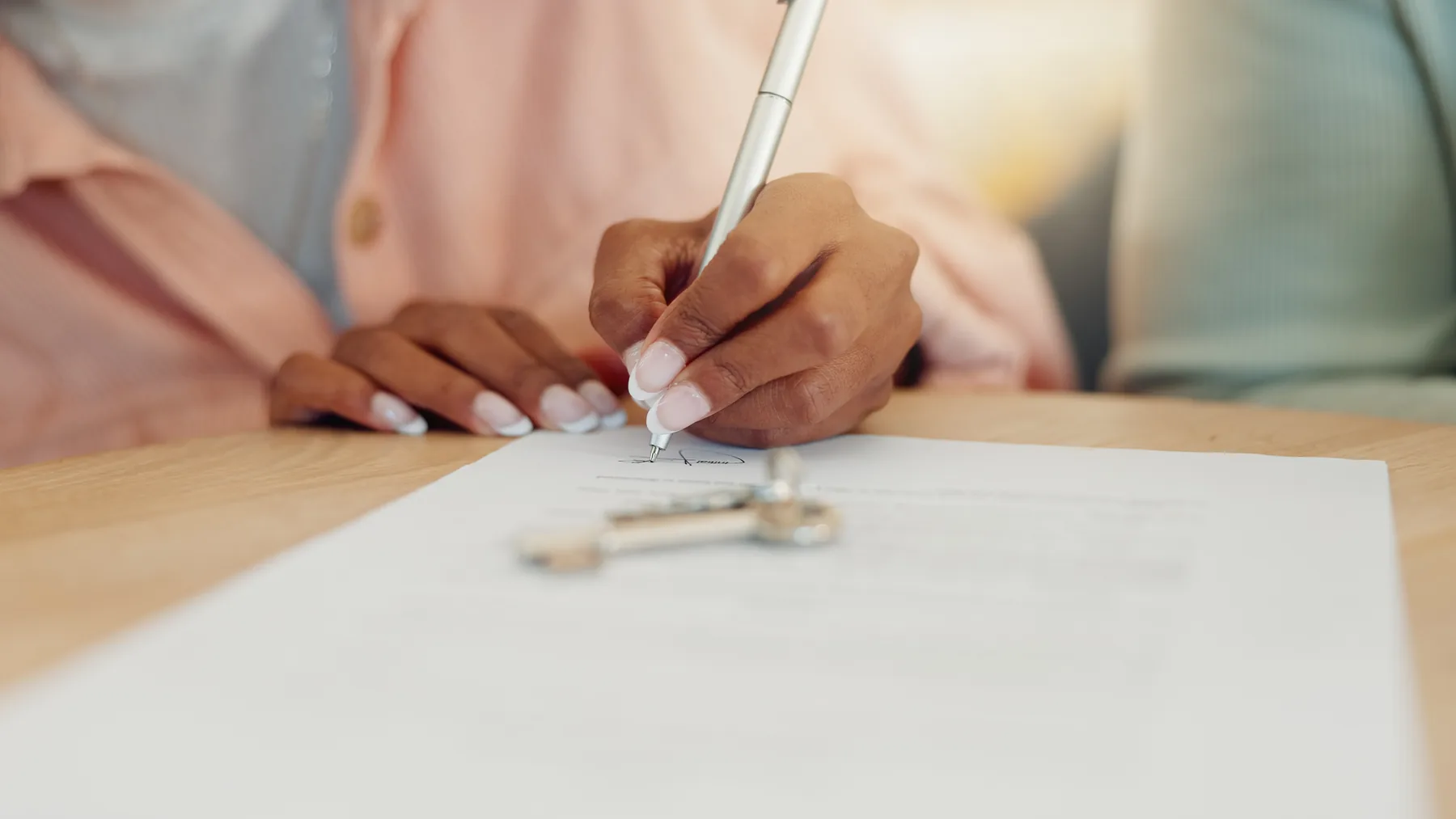 Firma de un acuerdo de compraventa junto a las llaves de la vivienda