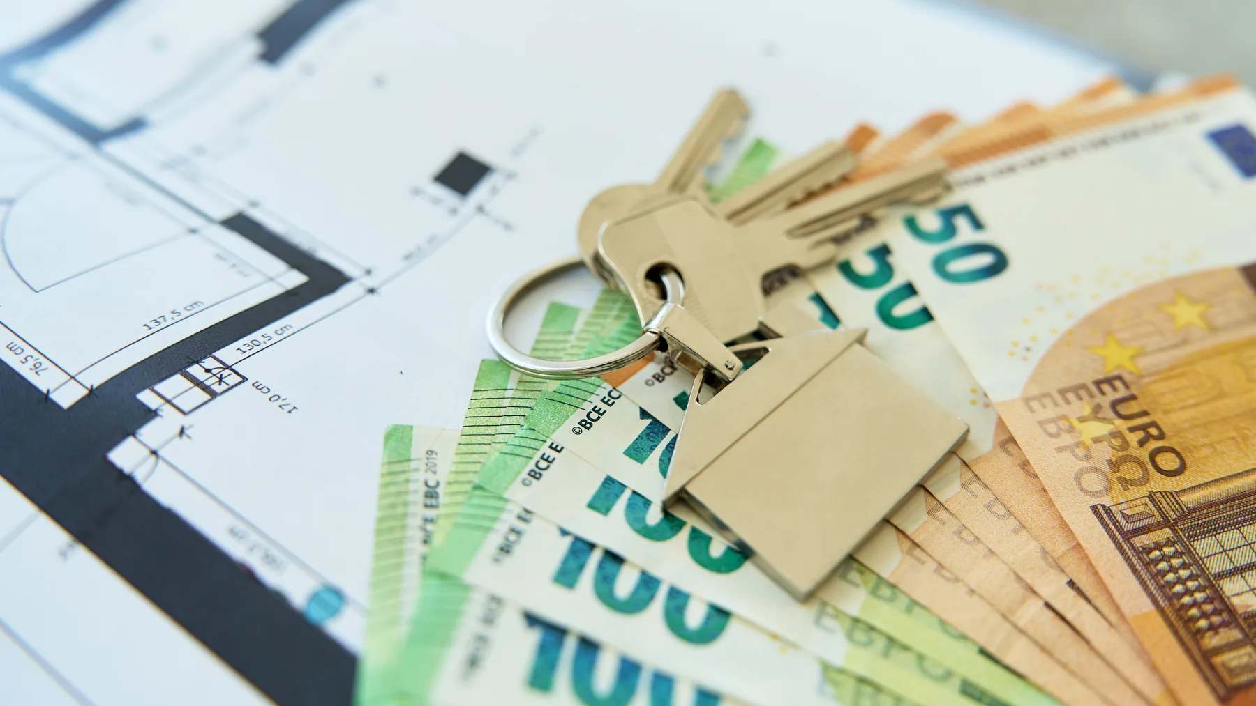 Llaves de vivienda, planos y euros para analizar una inversión inmobiliaria